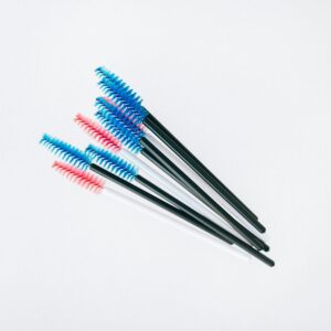 A set of colorful mascara applicator brushes arranged on a white background.