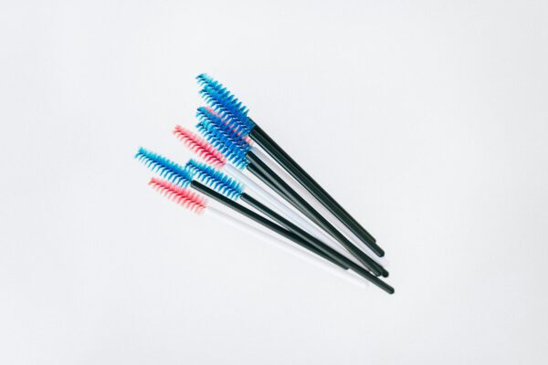 A set of colorful mascara applicator brushes arranged on a white background.